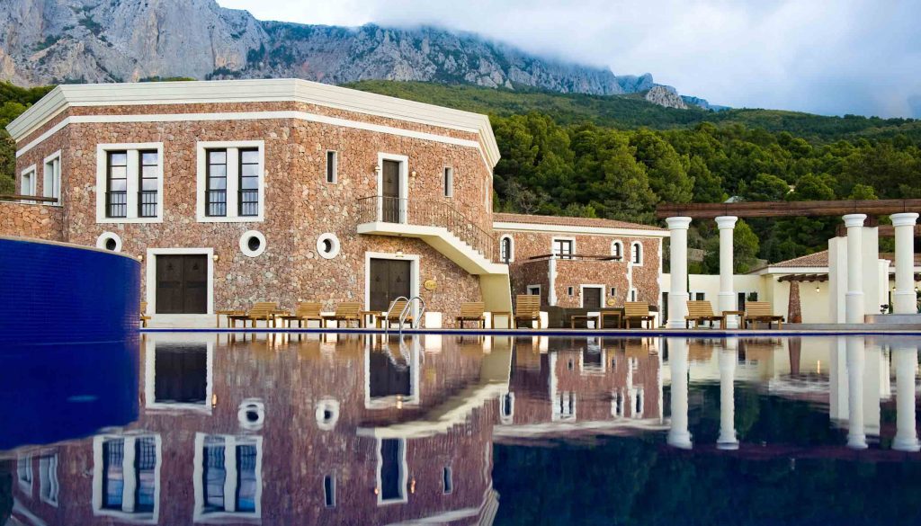 View of the main elevation of the hotel overlooking the swimming pool with wooden windows and doors