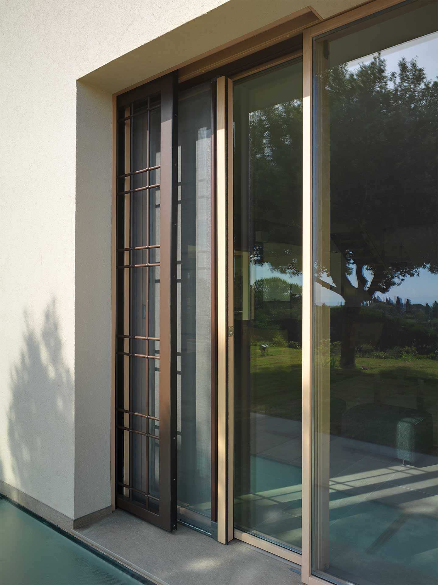 Villa Pisa, vista dell’alzante scorrevole con zanzariera e grata