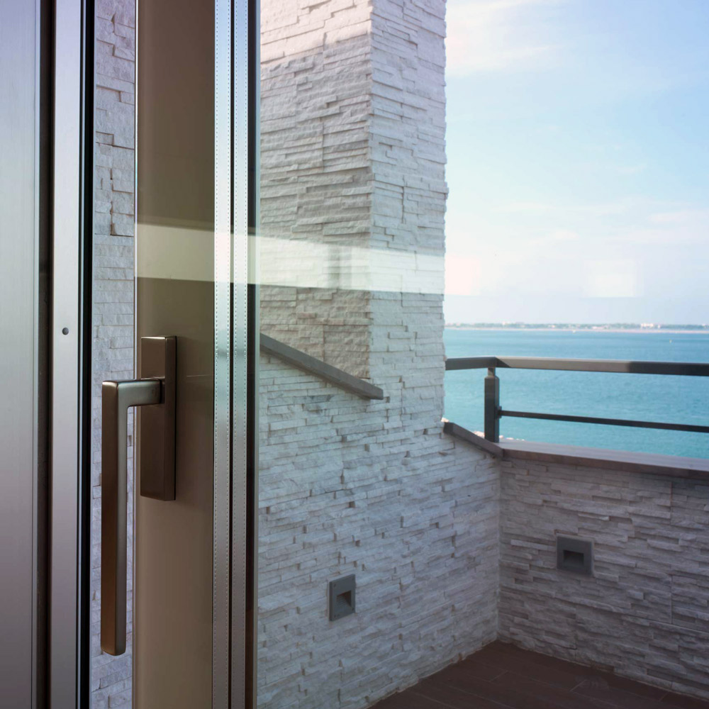 Vista di dettaglio di un alzante scorrevole in legno e vetro