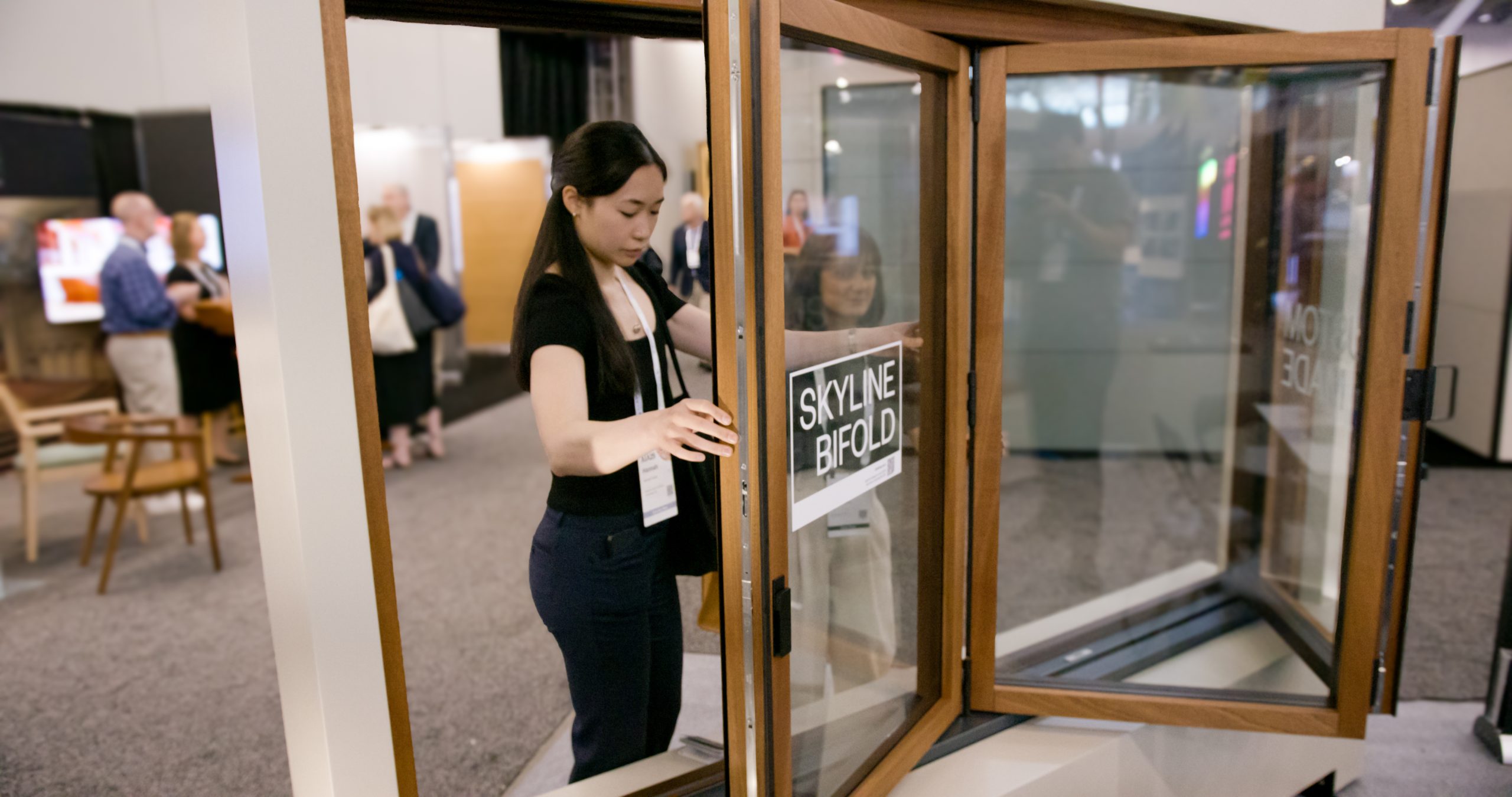 Ragazza che guarda il serramento Skyline Bifold alla AIA Conference 2025