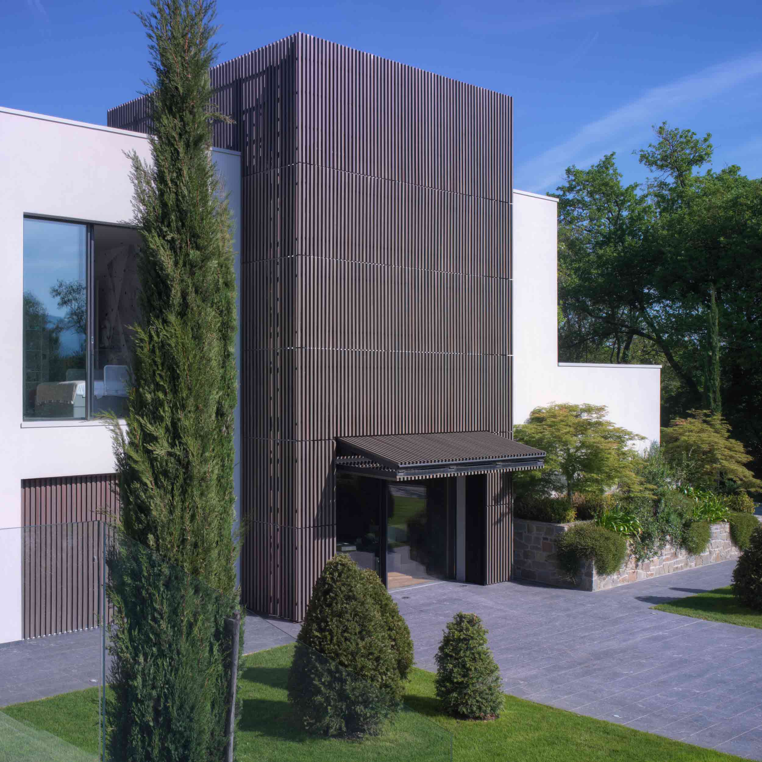 Vista del frangisole a ginocchiera di Carminati, con rivestimento in listelli di legno che continuano su tutta la facciata della villa
