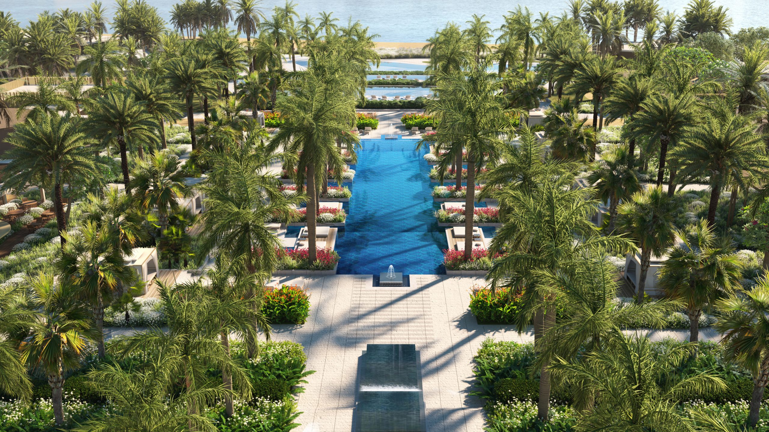 A luxury pool with palms leading to the sea.